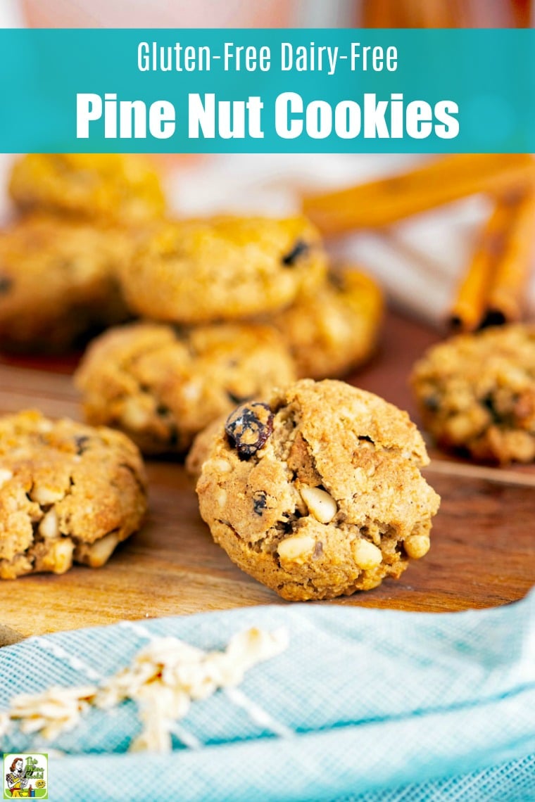 Close up of pine nuts and raisin cookies on a wooden cutting board.