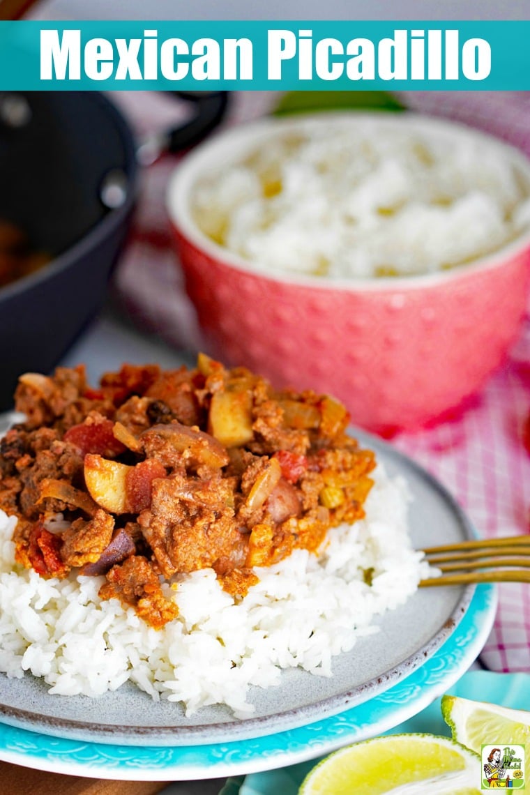 Plate of Mexican Picadillo on rice with brass fork with a pink bowl of rice and saute plan in the background.