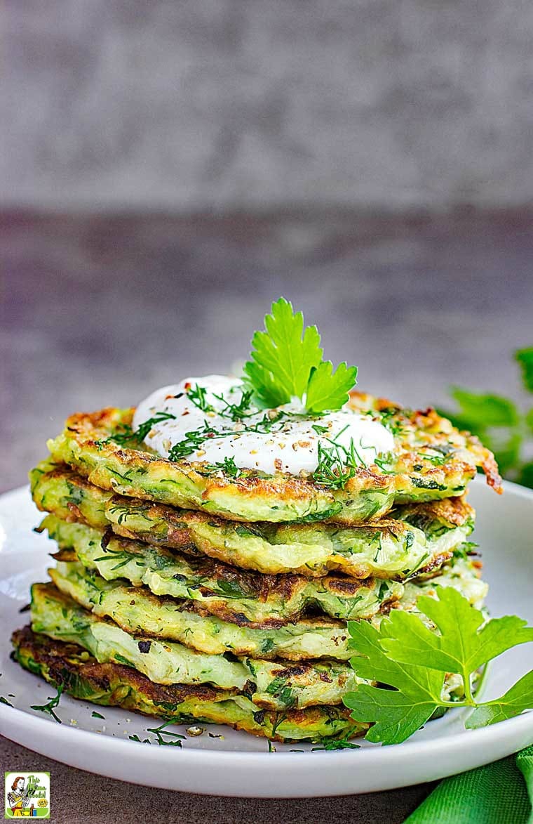Closeup of a plate of Zucchini Fritters with a dollop of Greek yogurt.