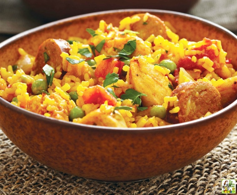 A brown bowl Chicken and Sausage Paella on a woven mat.