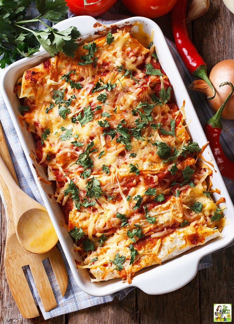 An Enchilada Casserole with wooden serving spoon and fork