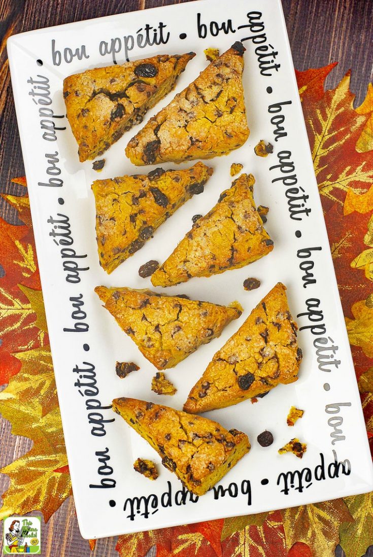 Pumpkin scones with chocolate chips on a white platter with bon appetit in black lettering.