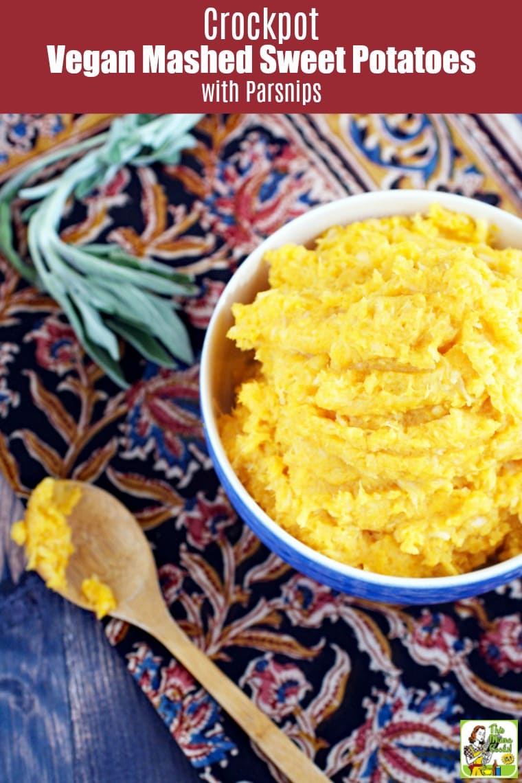 A sprig of sage, a wooden spoon, and a blue bowl of Mashed Sweet Potatoes with parsnips.