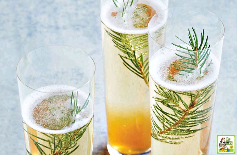 Three glasses of Juniper Champagne Cocktail with sprigs of pine.