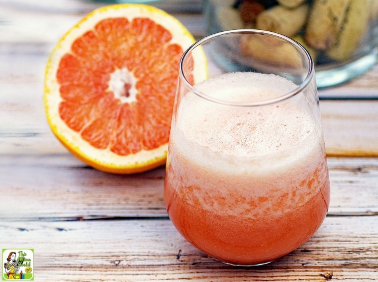 A glass of white wine cocktail with grapefruit.