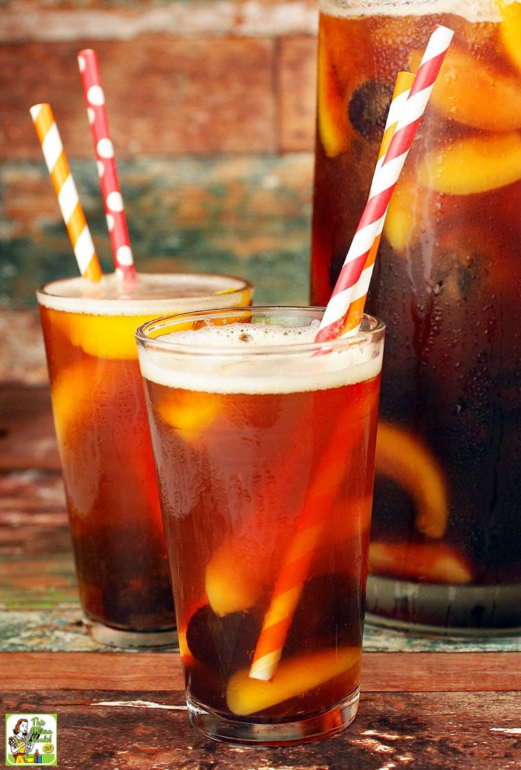 A pitcher and two glasses of iced tea with striped straws.