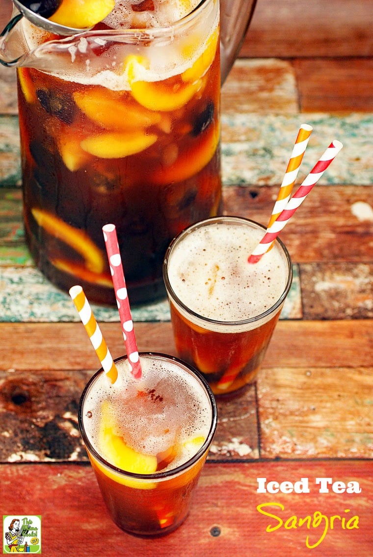 A pitcher and two glasses with colorful straws of iced tea sangria. 