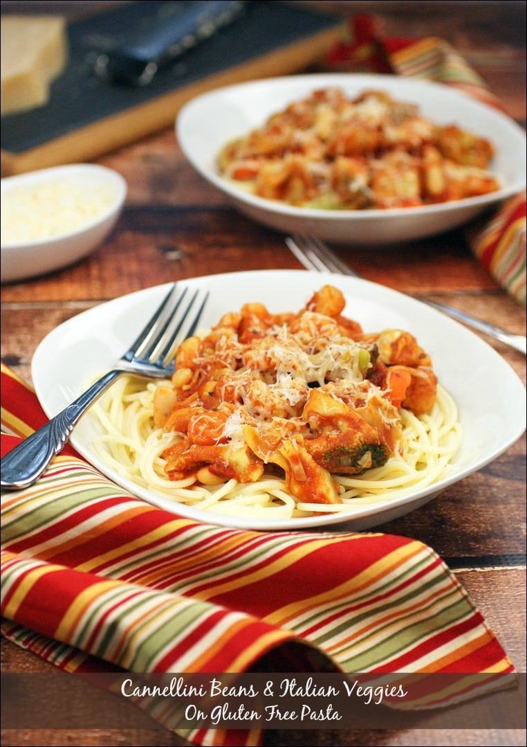 Closeup of a bowl of Pasta with Cannellini Beans & Italian Veggies with a striped napkins and forks.