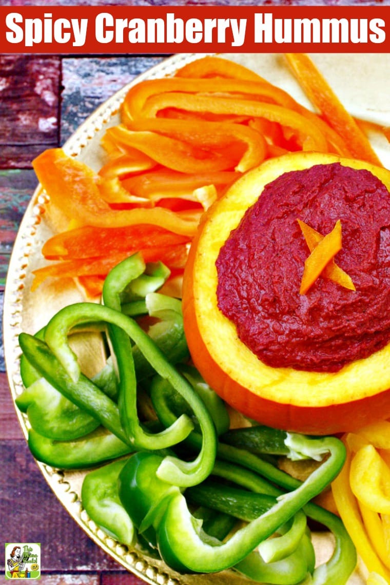 Overhead shot of a serving plate of sliced peppers served with Cranberry Hummus in a small pumpkin.