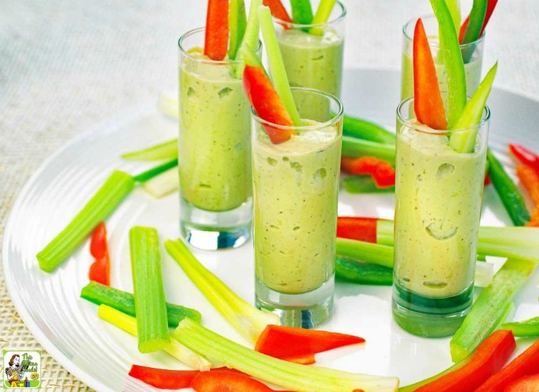 A tray of Avocado Dip Veggie Shooters and veggie sticks.