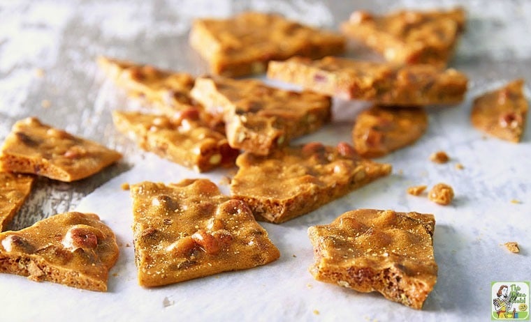 A pile of nut brittle on white parchment paper.