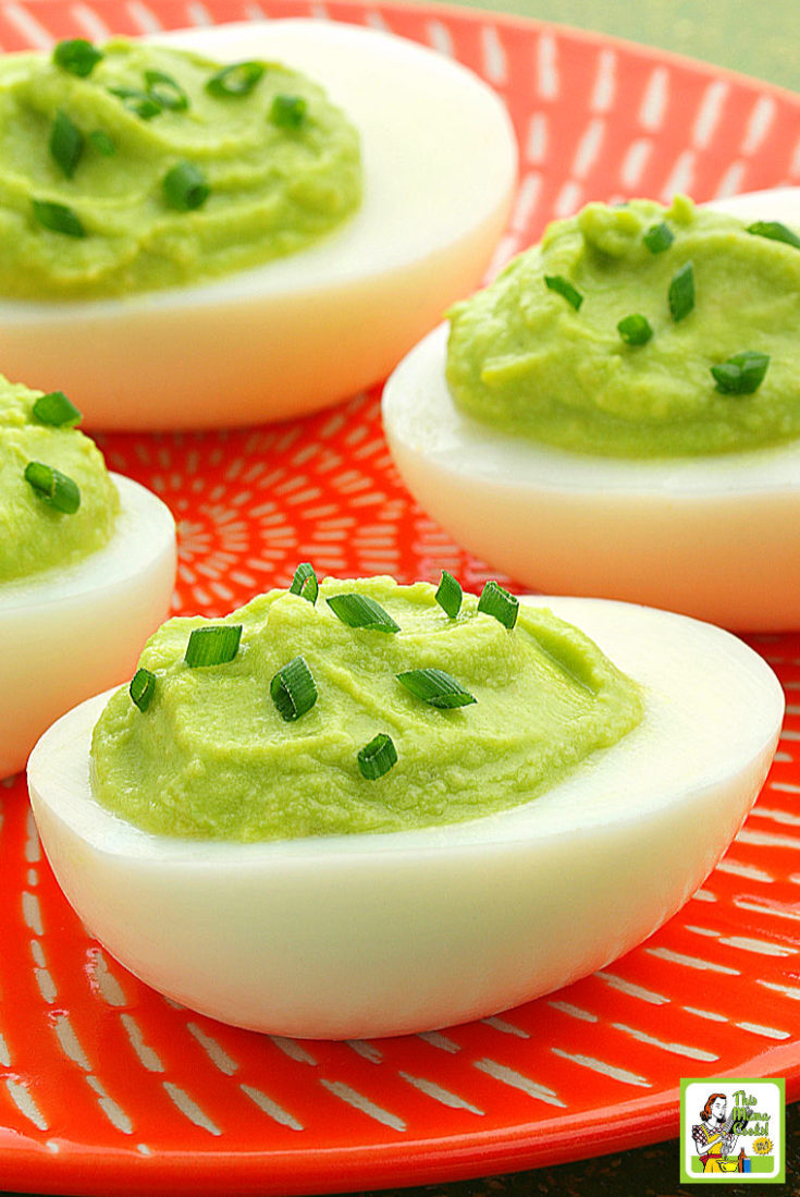 An orange plate filled with Avocado Deviled Eggs