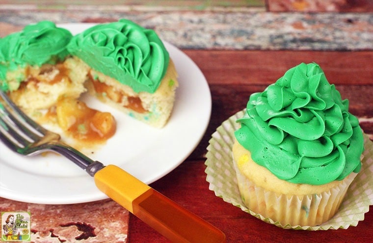 St. Patrick’s Day Pot of Gold Filled Cupcakes on a plate with fork and on a tabletop in a peeled back cupcake liner.