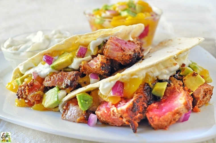 Ahi Tuna Tacos with Wasabi Cream and Mango Avocado Salsa on a white plate.