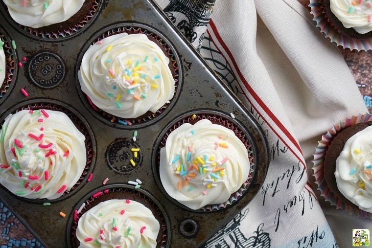 Gluten Free Cookie Dough Stuffed Cupcakes in a baking tin with a tea towel.