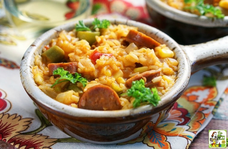 A lug bowl of One Pot Andouille Sausage Jambalaya on a colorful floral napkin.