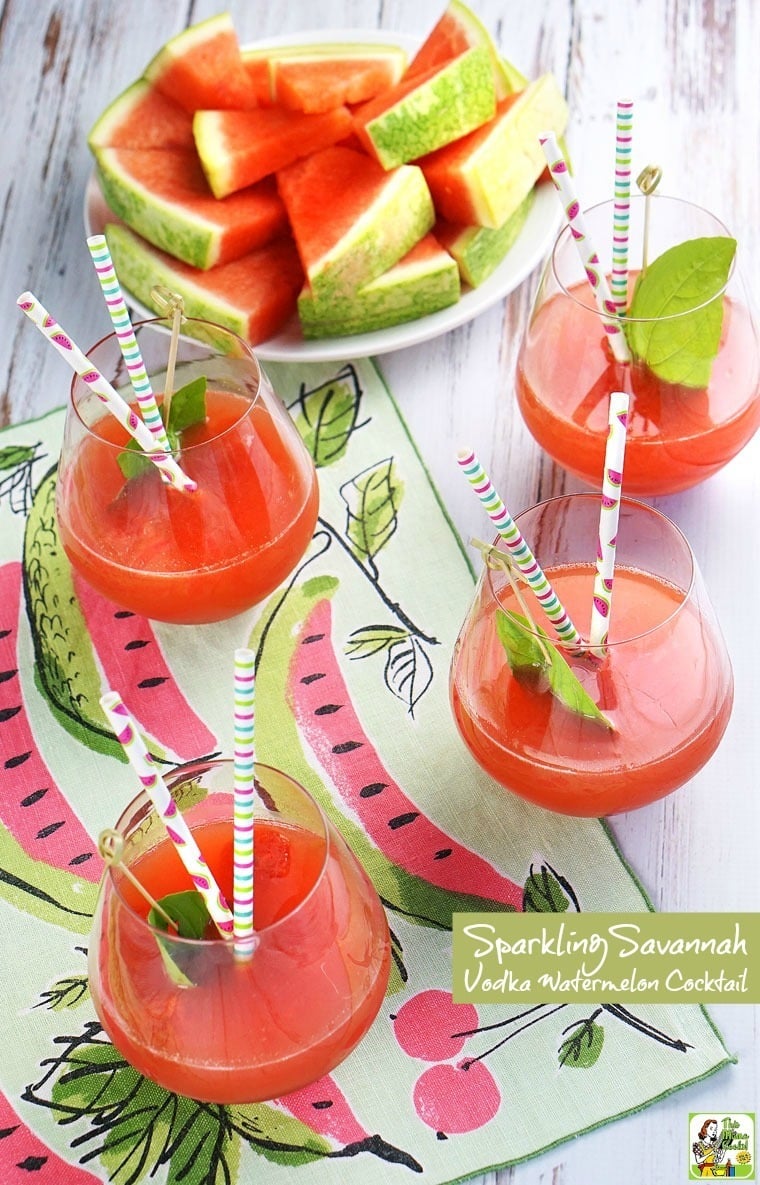 Four glasses of Vodka Watermelon Cocktails with colorful paper straws, and a plate of cut watermelon.