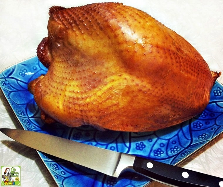Brined and smoked turkey breast on a blue plate with knife.