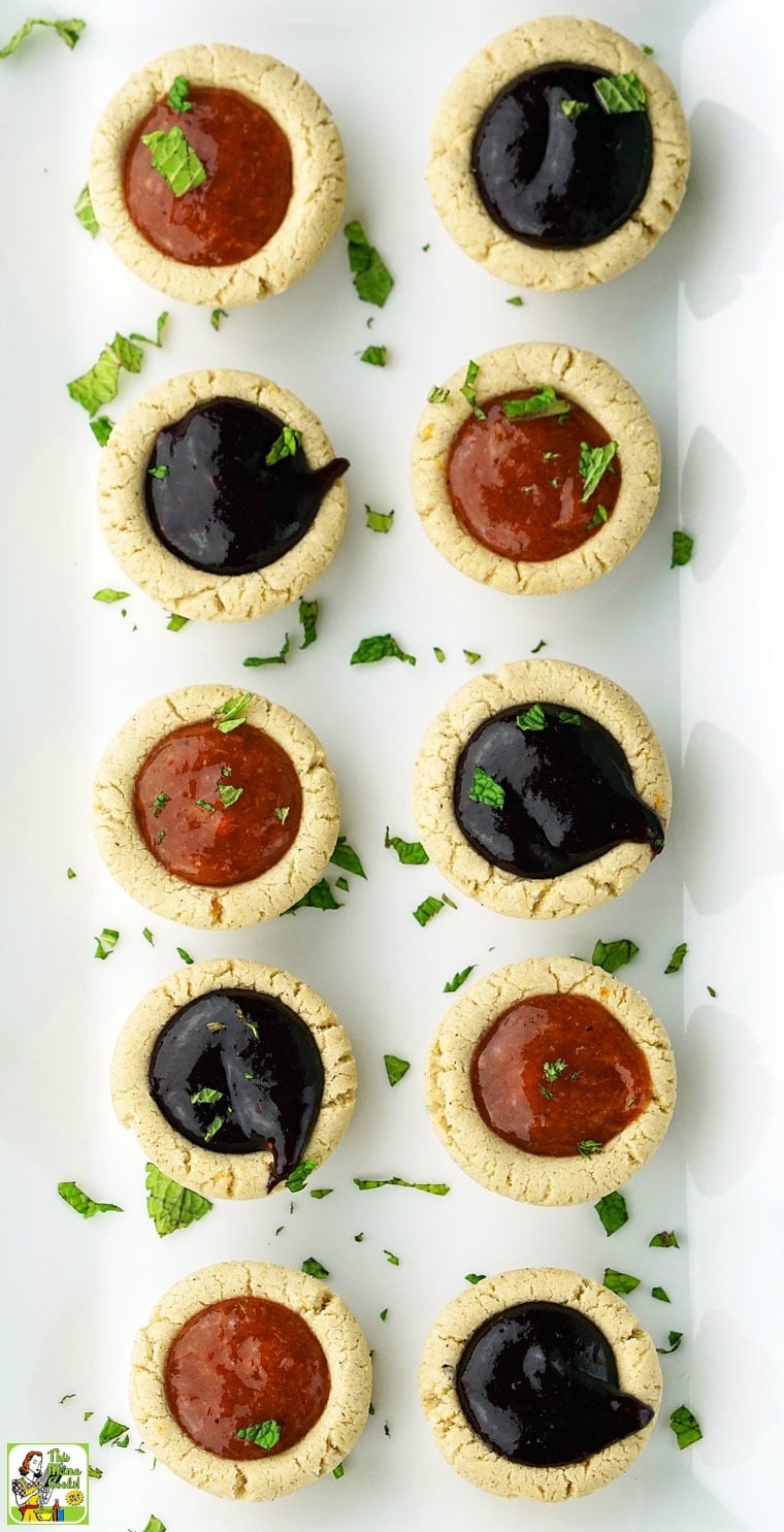 Two rows of fruit filled sugar cookie cups on a white ceramic platter.