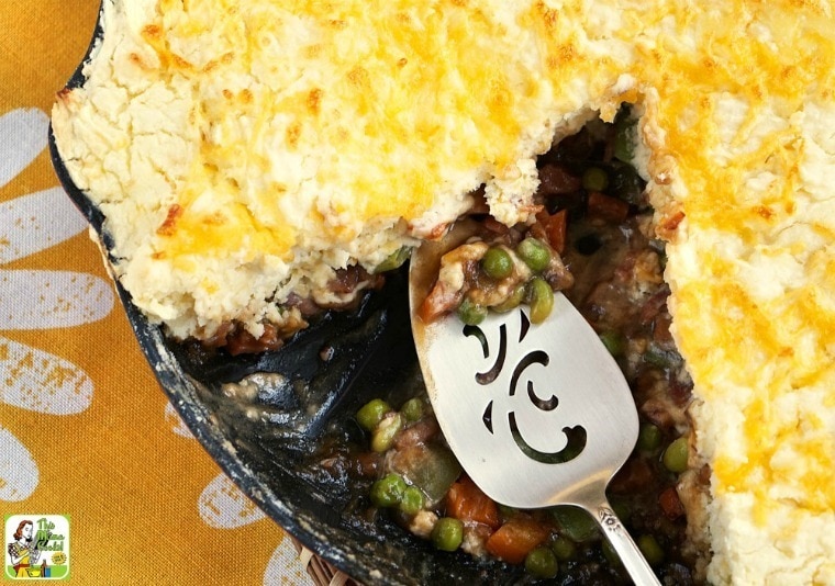 Pot Pie in a black skillet with vegetables with a silver server.