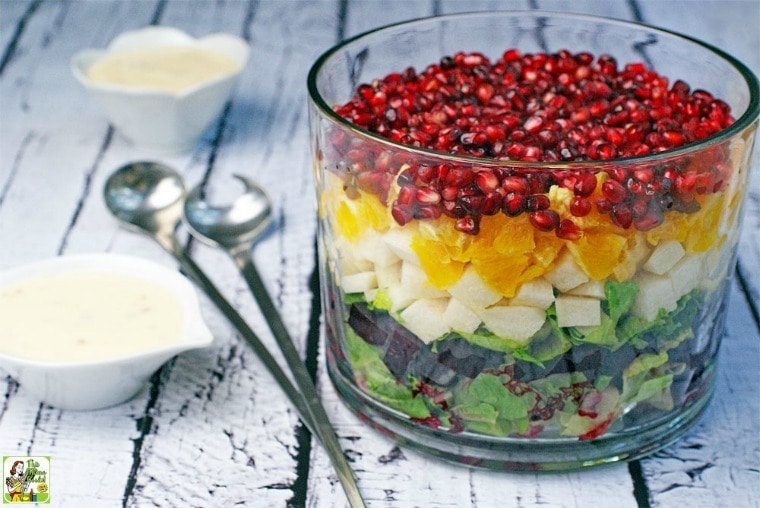 A layered Mexican Christmas Salad in a glass trifle bowl