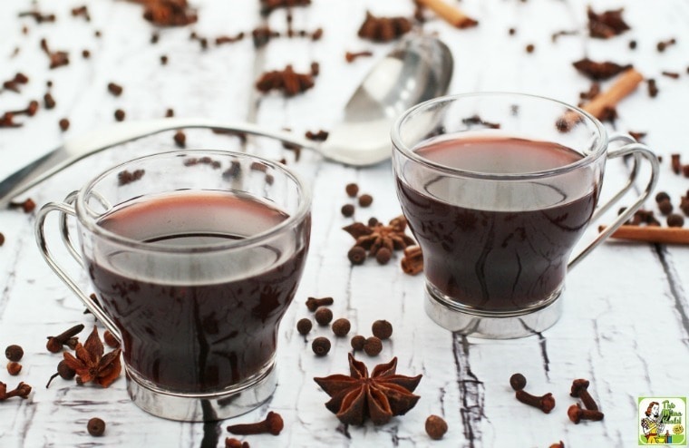 Slow cooker mulled wine in small glasses with metal handles.