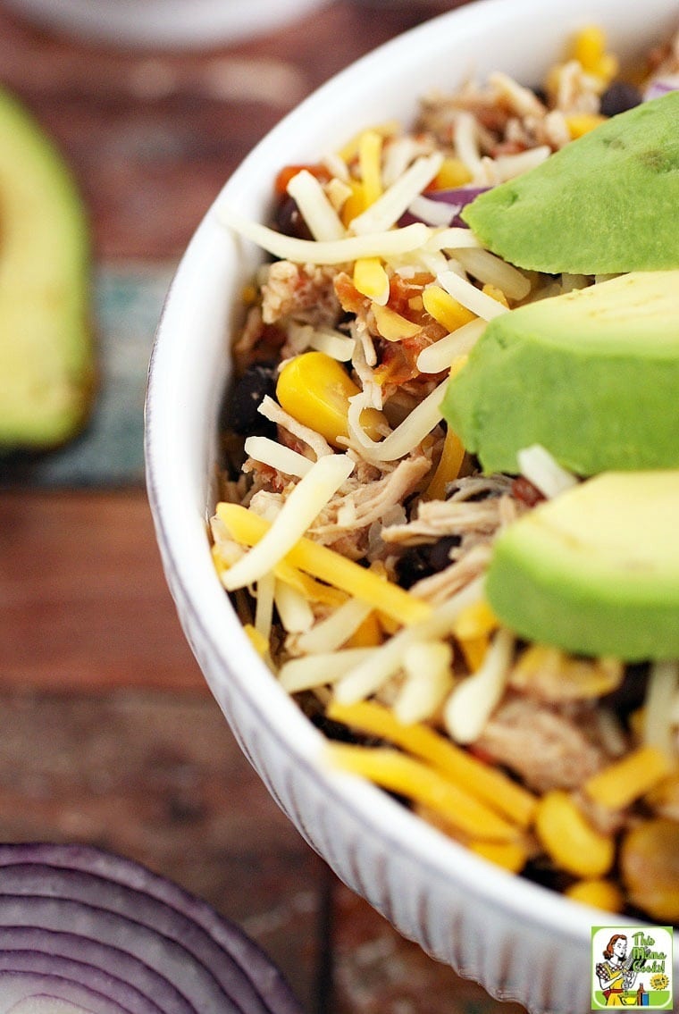 Close up of a bowl of Mexican Shredded Chicken Recipe with Black Beans & Corn with slices of avocado