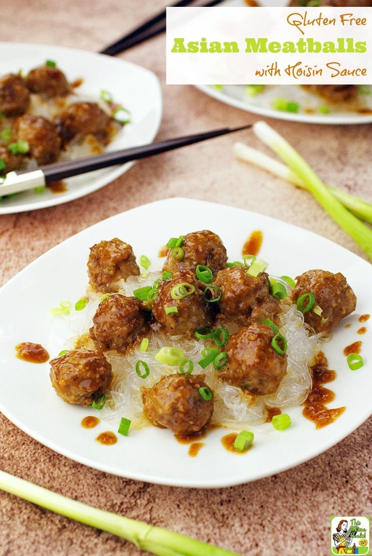 Closeup of Asian Meatballs with Hoisin Sauce on a white plate with chopped green onions on rice noodles.