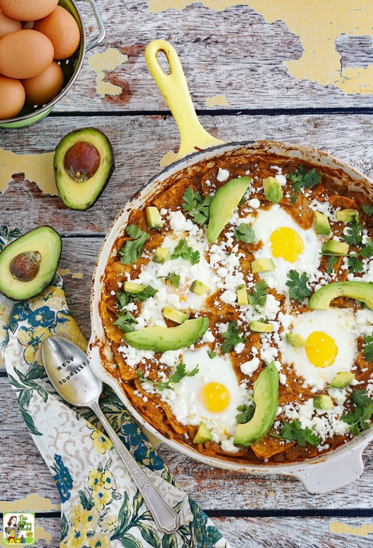 Overhead shot of a shillet of breakfast chilaquiles with avocados, eggs, crumbled queso fresco, cilantro, and salsa.
