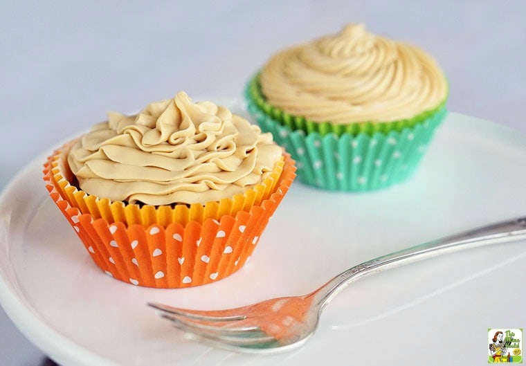 Two Gluten Free Chocolate Cupcakes with Dulce de Leche Frosting on a white plate with a fork.