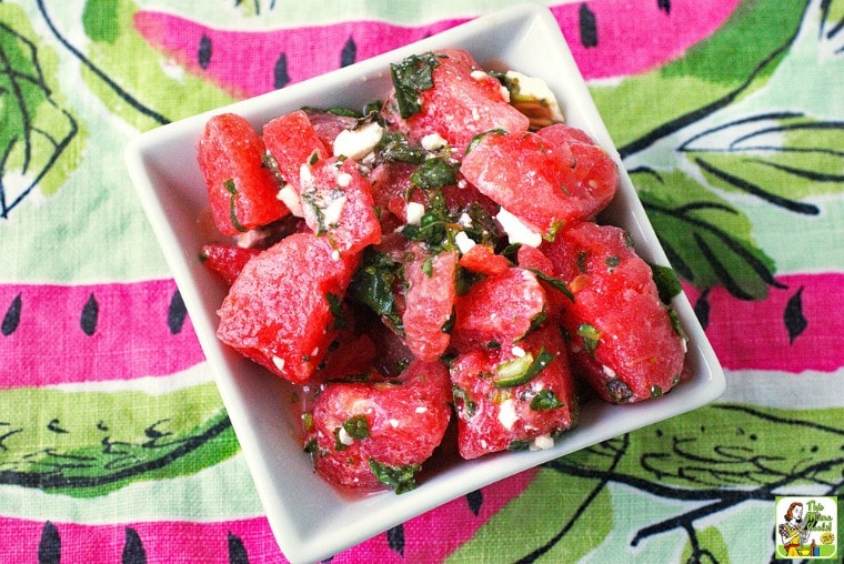 A bowl of Watermelon Salad with Mint & Feta on a watermelon printed napkin.
