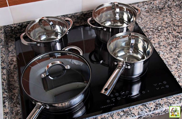 Pots and pans on an induction cooktop stove on a granite countertop.