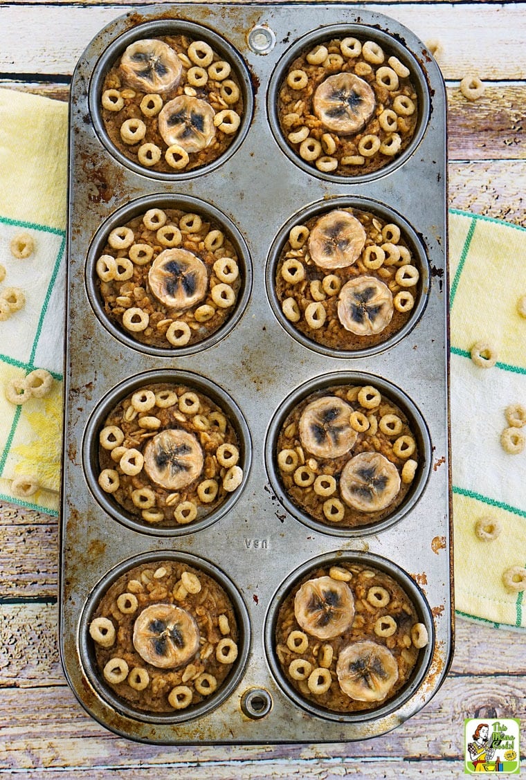 Gluten free banana muffins in a muffin tin on a yellow and white dish towel.