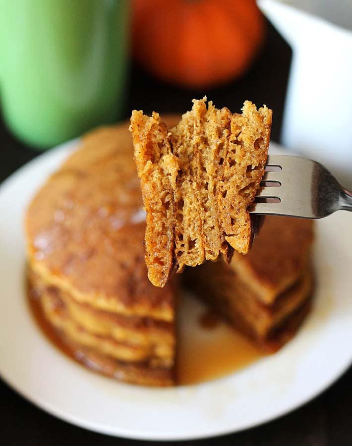 A forkful taken from a stack of Vegan Gluten Free Pumpkin Pancakes.