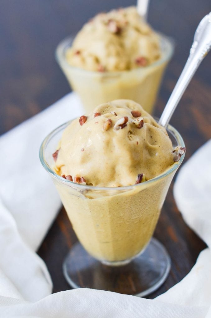 Glass dishes of melting Pumpkin Pie Ice Cream with spoon and napkin.