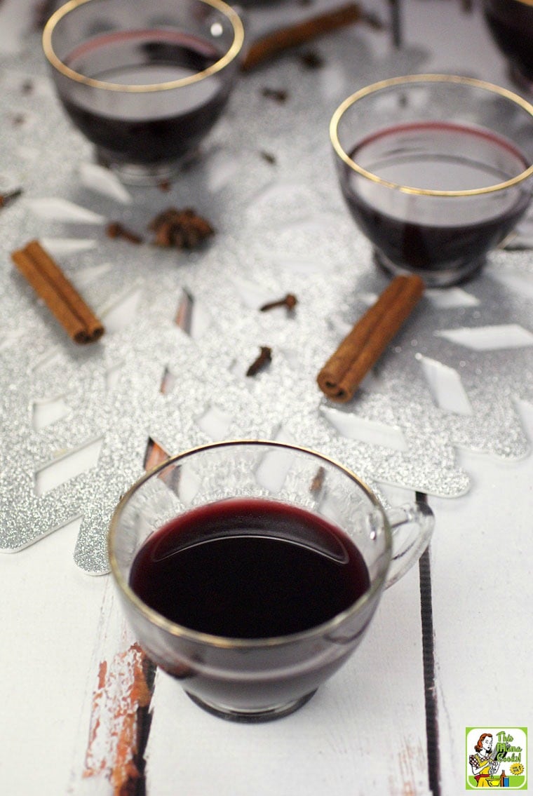 Glasses of slow cooker smoking bishop port wine cocktail and cinnamon sticks. 