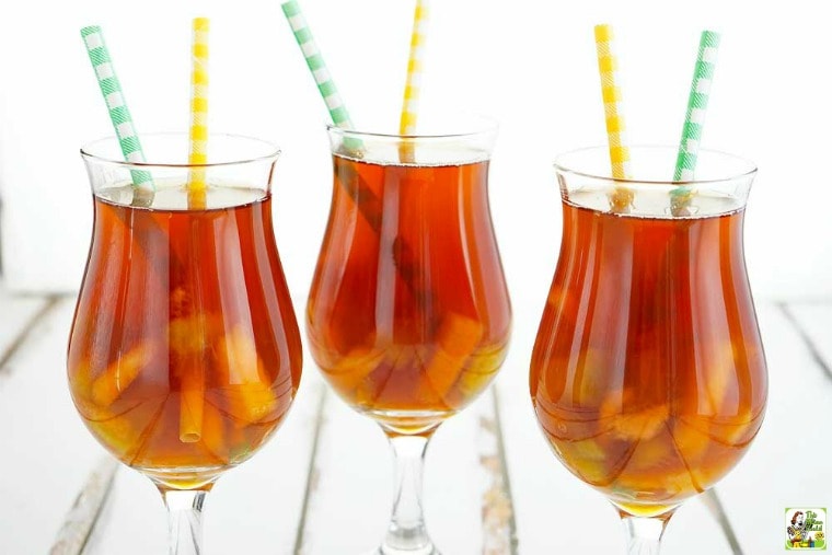 Three glasses of fruit iced tea with green and yellow straws.