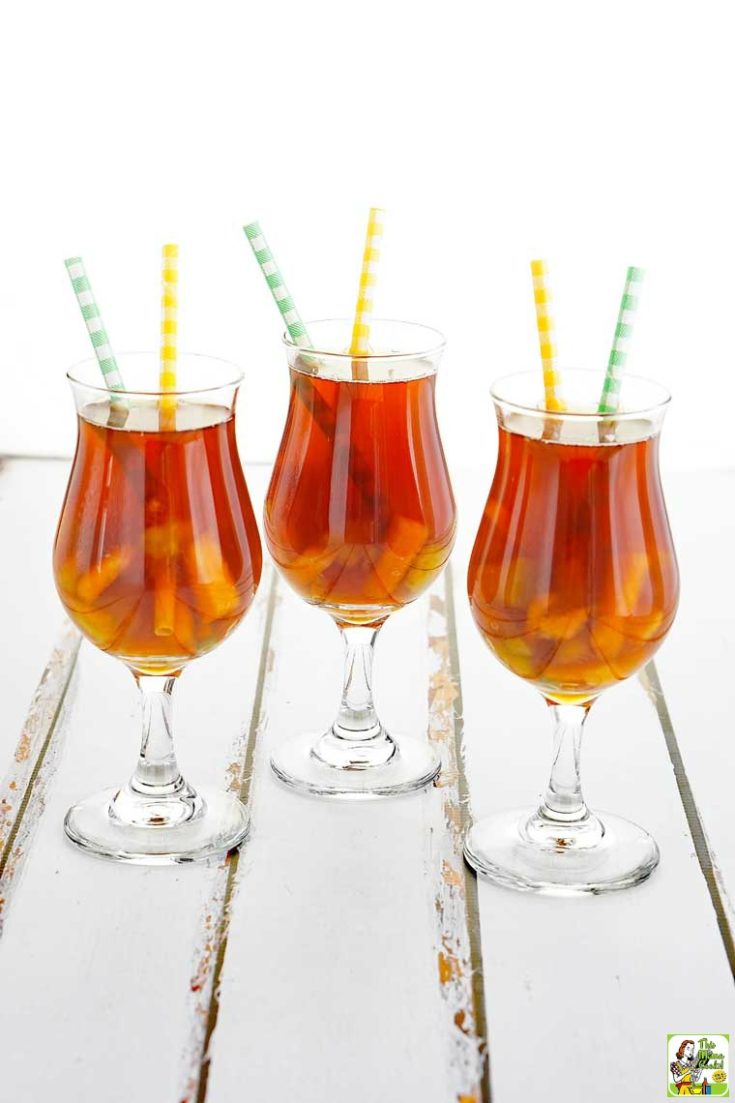 Three tall glasses of iced tea with yellow and green straws.