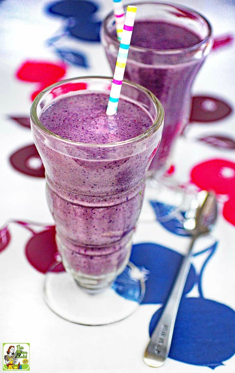 Berry smoothie served in a milk shake glass with a striped straw.