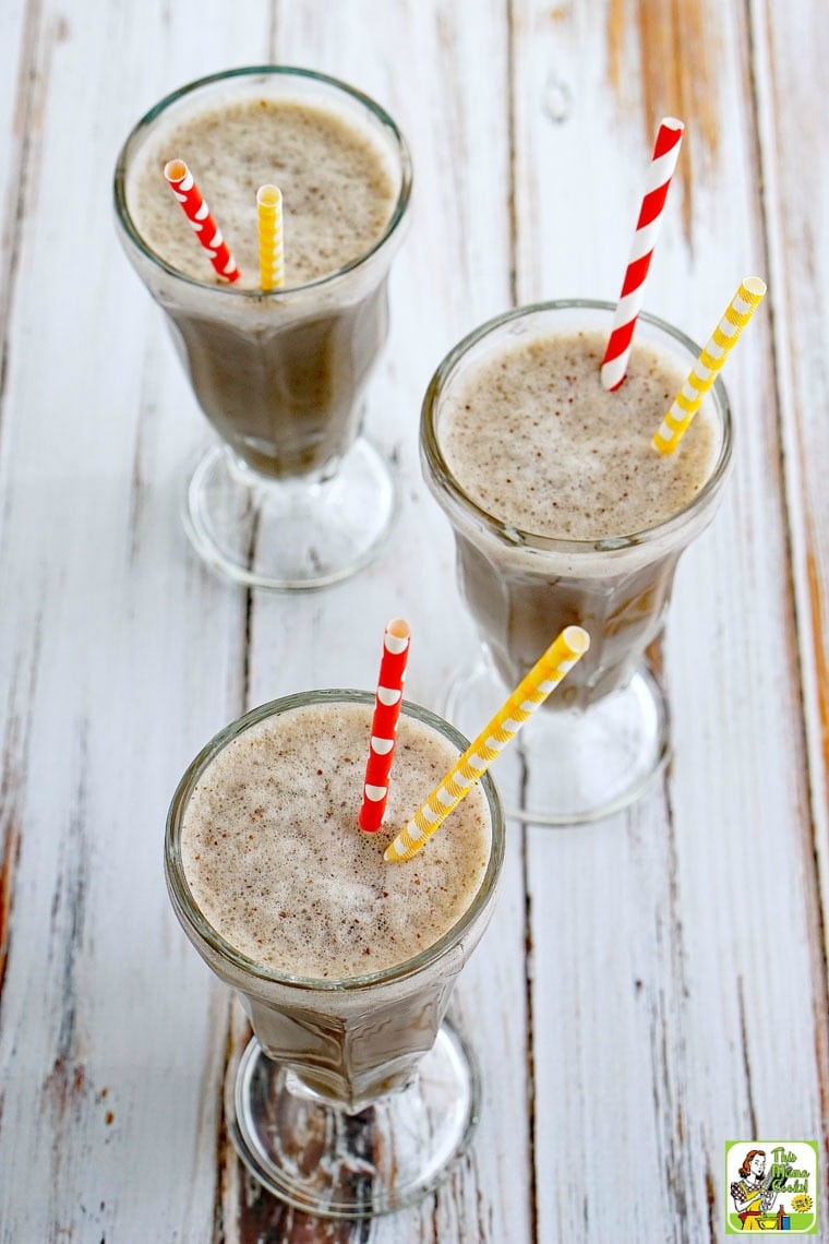 Three tall glasses of coffee smoothie drink with yellow and red straws.