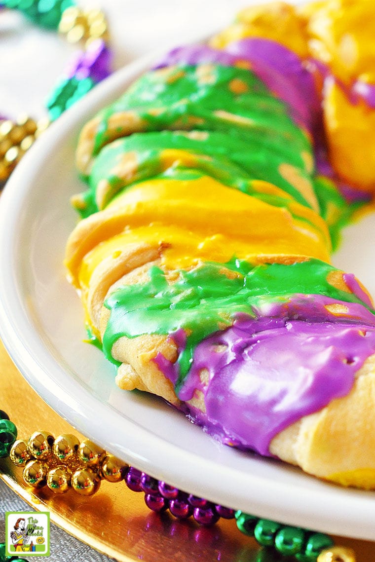 Mardi Gras King Cakes on a white plate with green and gold Mardi Gras beads.