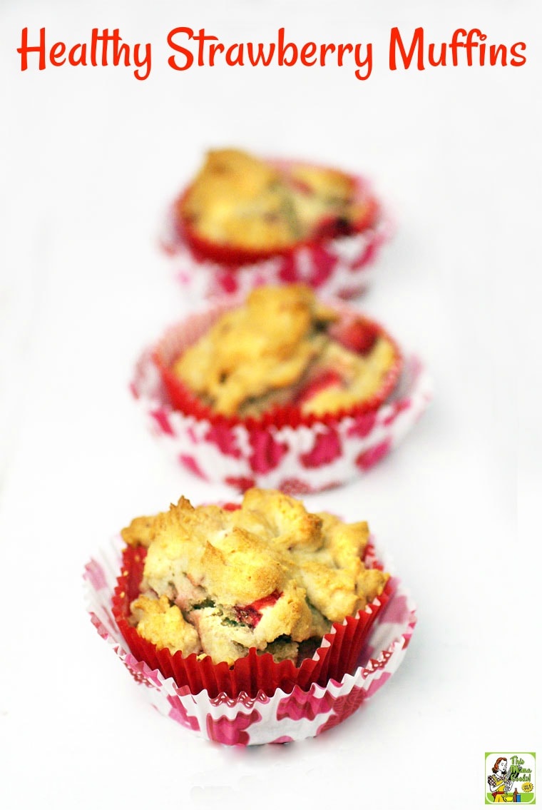 Three Strawberry Muffins on a white tabletop.