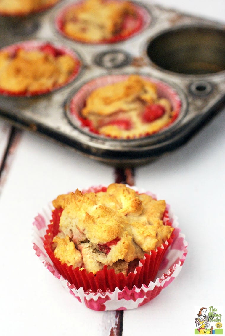 Muffin baking pan and strawberry muffins in a red and white decorative cupcake liner.