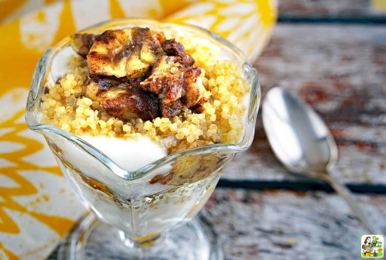 Fruit and Yogurt Parfait Recipe with Quinoa in a parfait glass with yellow napkin and spoon.