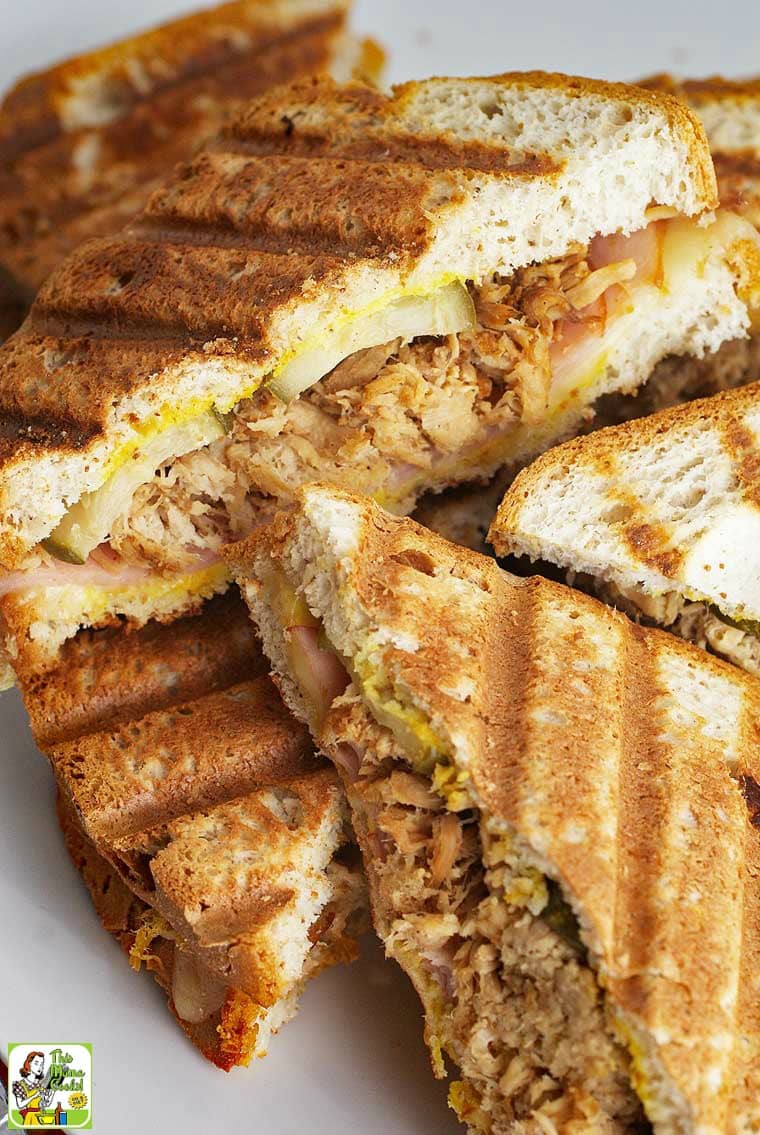 Closeup of Cuban panini sandwiches on a white platter.