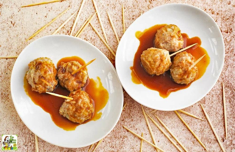 Asian Style Gluten Free Meatballs in dipping sauce served in white plates with toothpicks.