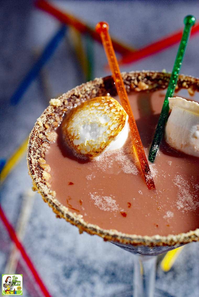 Closeup of chocolate Smores Martini served with toasted marshmallows. Glass rimmed with chocolate and cookie crumbs.