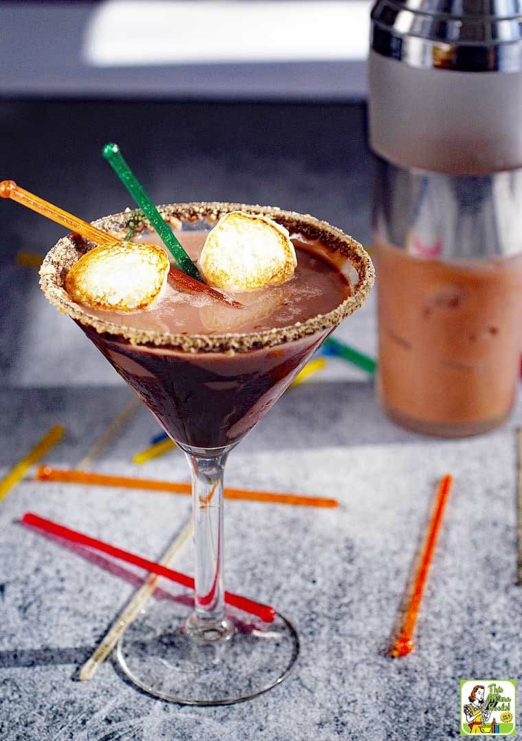 Chocolate Smores Martini served with toasted marshmallows with cocktail shaker in background.
