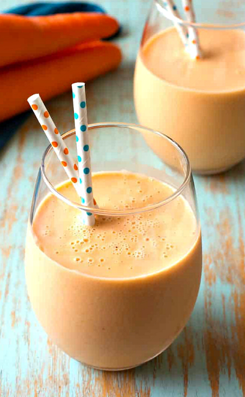 A glass of Orange Carrot Smoothie with straws.