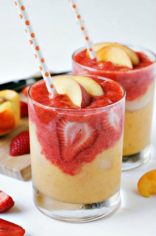 Glasses of Roasted Strawberry Peach Smoothie with strawberry slices.